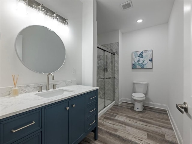 bathroom with vanity, wood-type flooring, toilet, and an enclosed shower