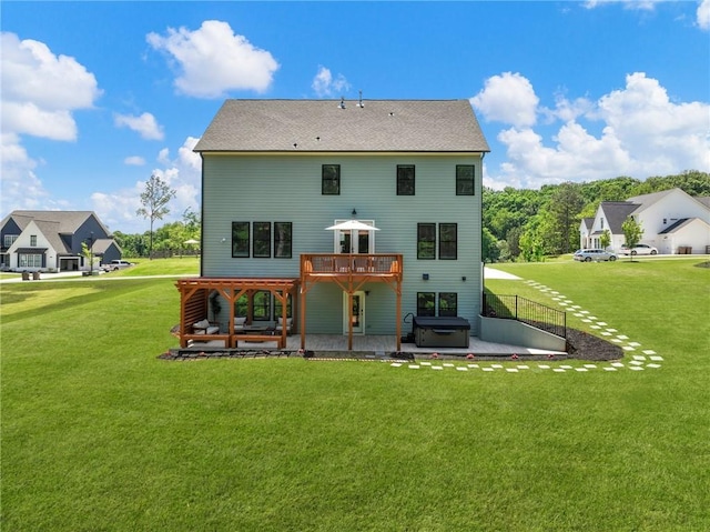 back of house with a hot tub, a patio area, and a yard