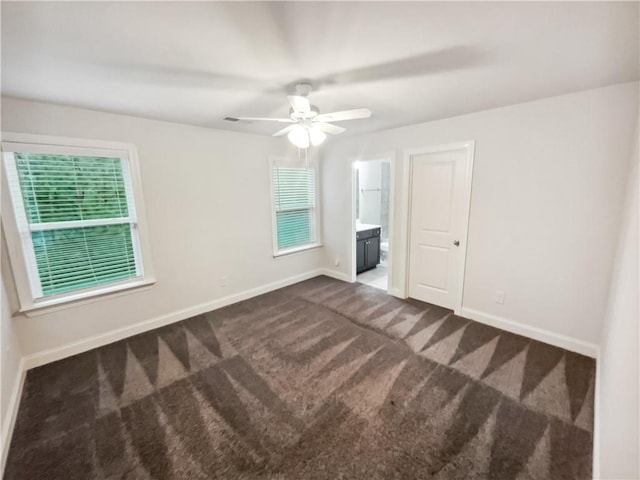 3650 Lindsy Brooke Ct, Douglasville, GA 30135 - unfurnished bedroom featuring dark carpet, baseboards, ensuite bathroom, and ceiling fan
