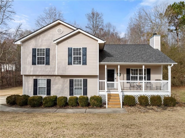 tri-level home featuring covered porch and a front yard