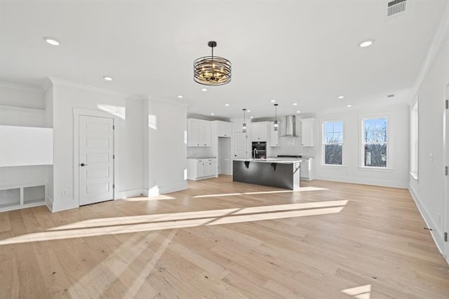 unfurnished living room featuring visible vents, a notable chandelier, light wood-style floors, ornamental molding, and recessed lighting
