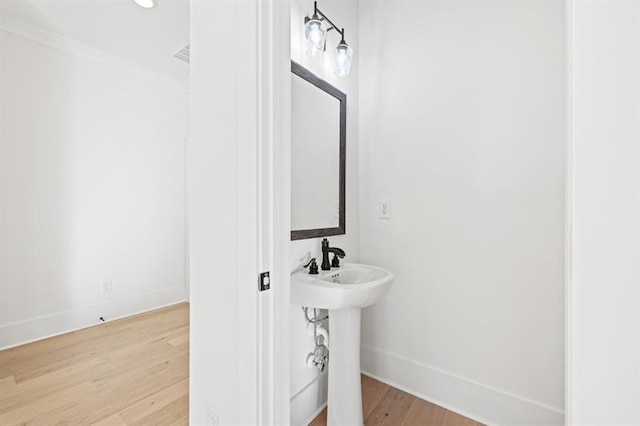 bathroom featuring baseboards, a sink, and wood finished floors