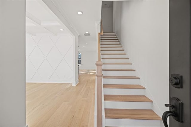 staircase featuring beam ceiling, coffered ceiling, recessed lighting, and wood finished floors
