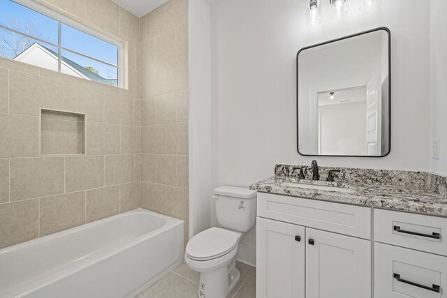 full bathroom with tiled shower / bath combo, tile patterned floors, toilet, and vanity