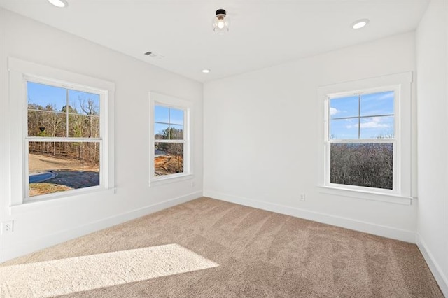 carpeted spare room featuring baseboards and recessed lighting