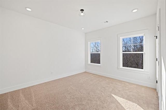 spare room with baseboards, recessed lighting, and light carpet