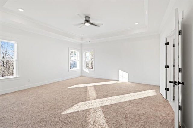 carpeted empty room featuring a raised ceiling, ornamental molding, recessed lighting, and ceiling fan