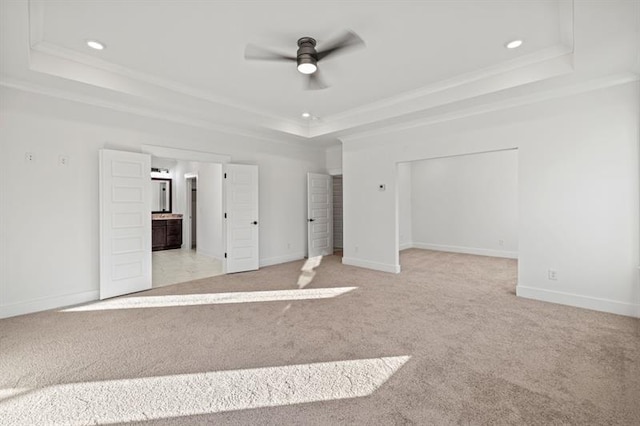 unfurnished bedroom with crown molding, recessed lighting, light colored carpet, and a raised ceiling