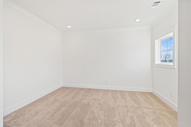 spare room with baseboards, ornamental molding, and light carpet