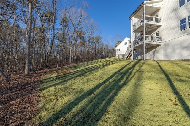 view of yard with stairs and a balcony