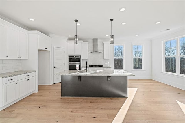kitchen featuring recessed lighting, stainless steel double oven, wall chimney exhaust hood, and tasteful backsplash