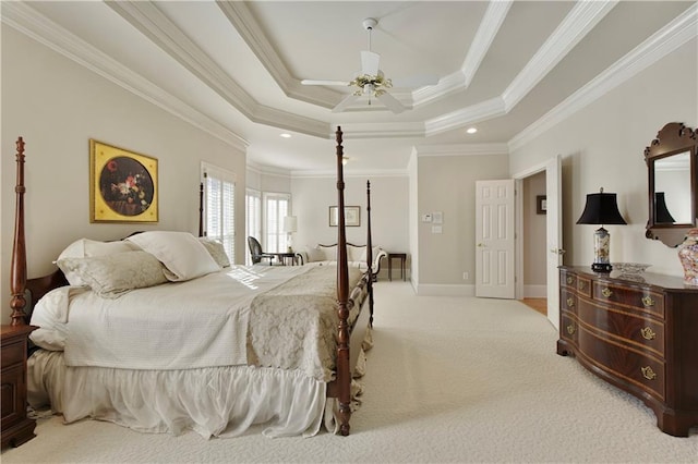 bedroom with ornamental molding, a tray ceiling, light carpet, and ceiling fan