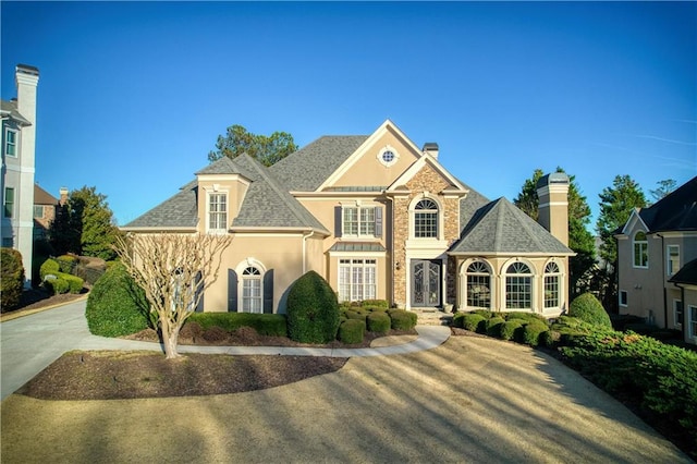 view of front of home featuring roof with shingles and stucco siding