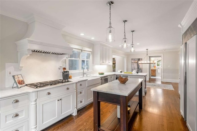 kitchen with a sink, crown molding, a peninsula, light countertops, and stainless steel appliances