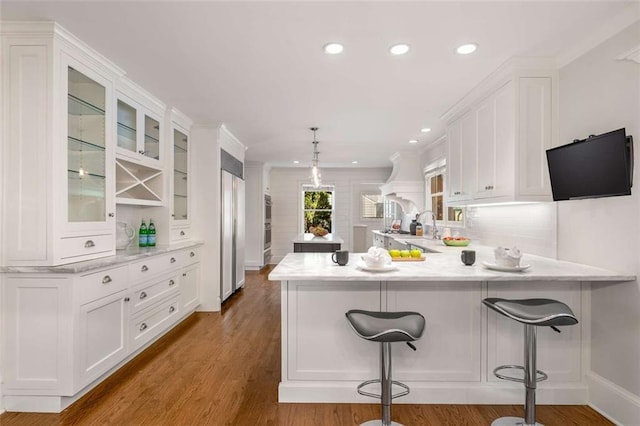 kitchen with white cabinets, glass insert cabinets, a peninsula, recessed lighting, and light countertops