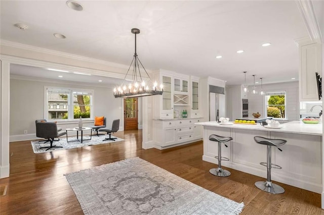 kitchen featuring glass insert cabinets, white cabinets, plenty of natural light, crown molding, and recessed lighting