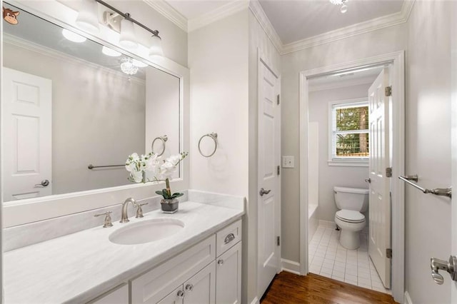 bathroom featuring toilet, vanity, a bath, crown molding, and wood finished floors
