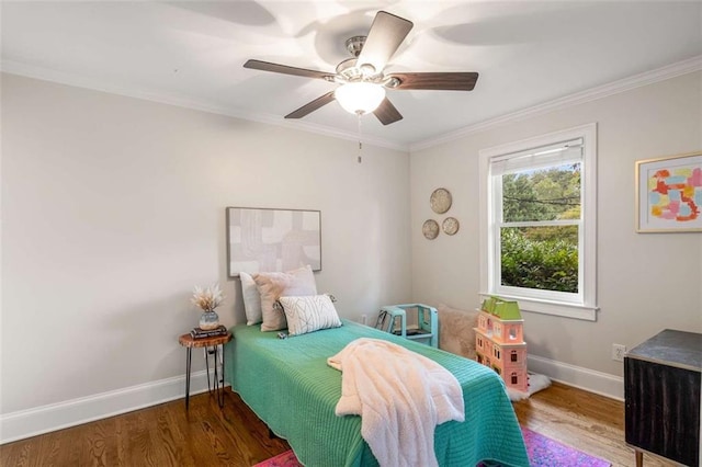 bedroom featuring wood finished floors, baseboards, ornamental molding, and a ceiling fan