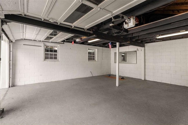 garage with a garage door opener and concrete block wall