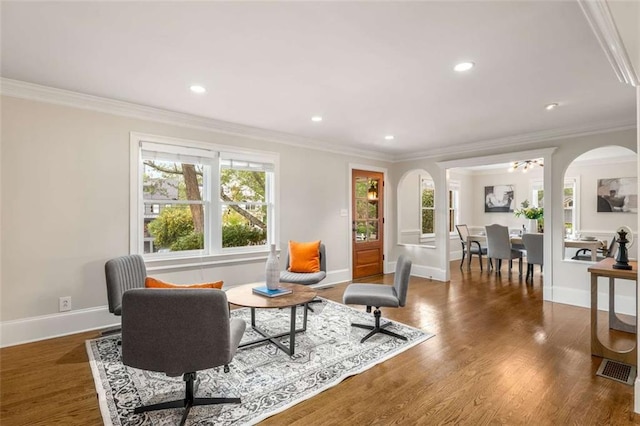 living room with crown molding, baseboards, wood finished floors, recessed lighting, and arched walkways