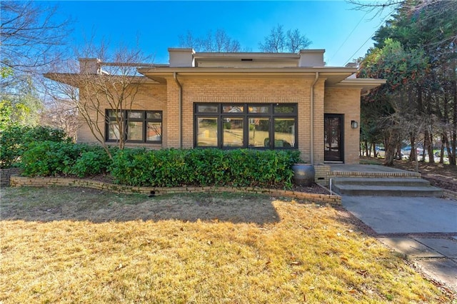 view of front of property with brick siding and a front lawn