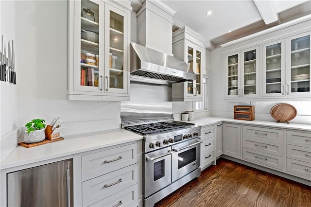 kitchen featuring beverage cooler, range with two ovens, dark wood-type flooring, light countertops, and wall chimney exhaust hood