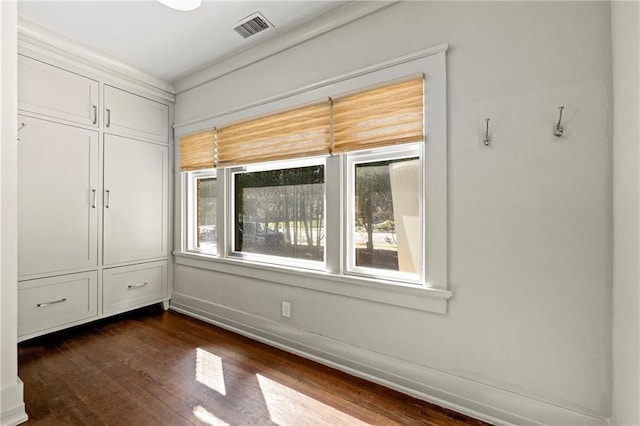 unfurnished bedroom with visible vents, baseboards, and dark wood-style flooring