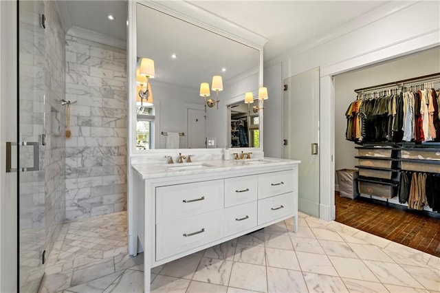 full bath featuring a sink, marble finish floor, a shower stall, and ornamental molding