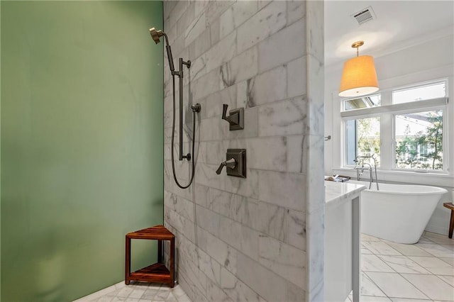 bathroom featuring a freestanding tub, visible vents, and tiled shower