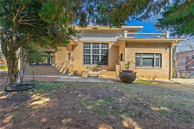 rear view of property featuring a patio area and brick siding