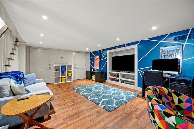 living room with recessed lighting, visible vents, wood finished floors, and stairs