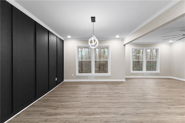 unfurnished dining area featuring ornamental molding, ceiling fan, a healthy amount of sunlight, and light hardwood / wood-style flooring