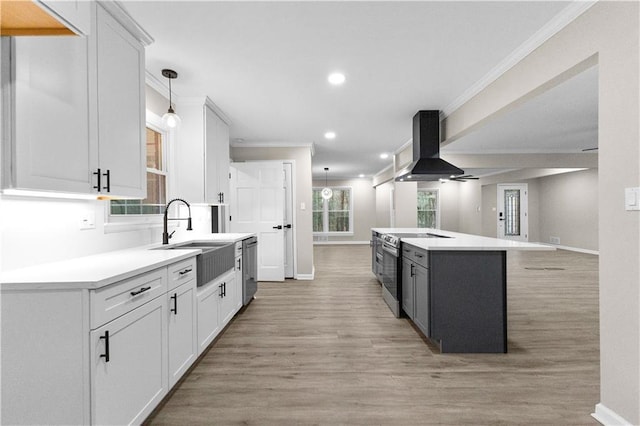 kitchen featuring white cabinets, appliances with stainless steel finishes, a kitchen island, island exhaust hood, and sink