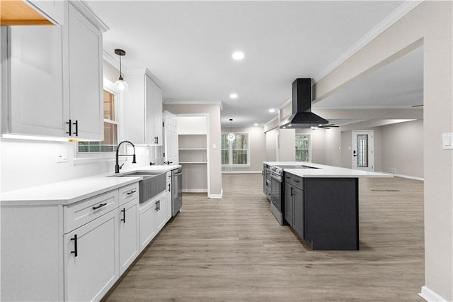 kitchen with white cabinets, a center island, exhaust hood, and appliances with stainless steel finishes