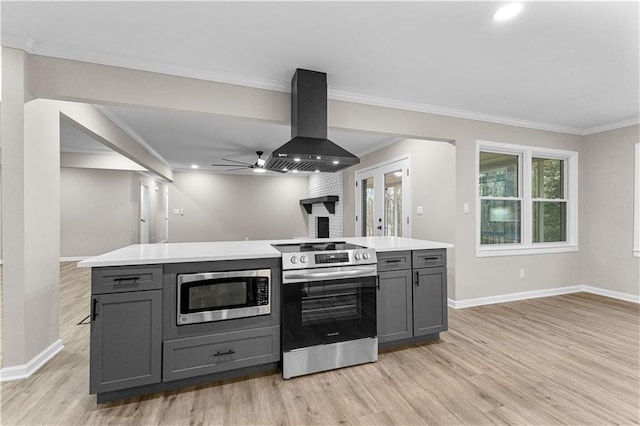 kitchen with crown molding, gray cabinets, island exhaust hood, and stainless steel appliances