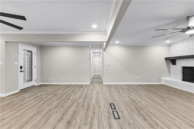 unfurnished living room featuring light wood-type flooring, ceiling fan, crown molding, and a fireplace