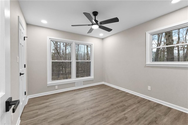 empty room with hardwood / wood-style floors, a healthy amount of sunlight, and ceiling fan