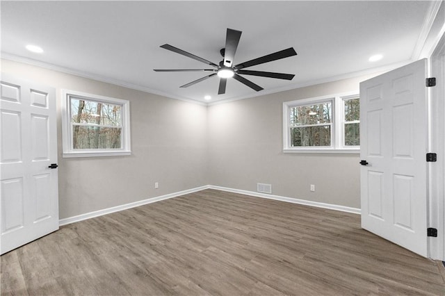 unfurnished bedroom with ceiling fan, multiple windows, hardwood / wood-style floors, and ornamental molding