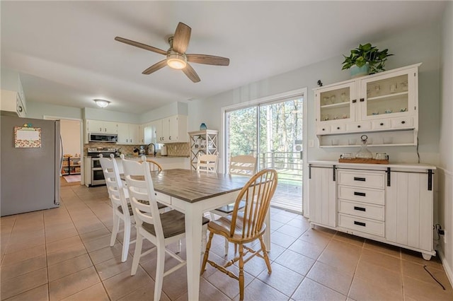 dining space featuring light tile patterned floors and a ceiling fan