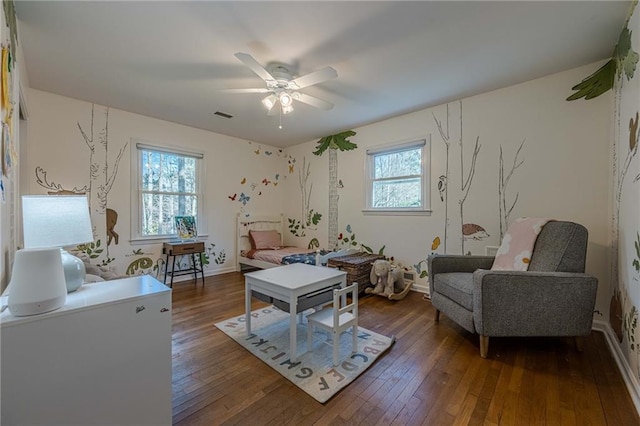 living area featuring visible vents, baseboards, a ceiling fan, and hardwood / wood-style floors