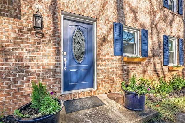 view of exterior entry with brick siding