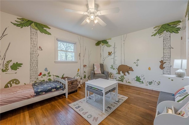 bedroom featuring baseboards, hardwood / wood-style floors, and a ceiling fan