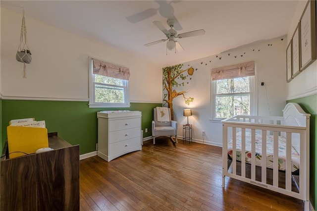 bedroom with multiple windows, baseboards, and hardwood / wood-style flooring