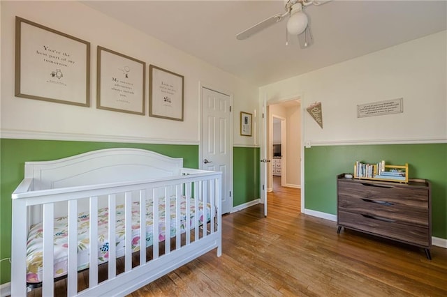 bedroom with ceiling fan, baseboards, and wood finished floors