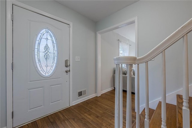 foyer entrance featuring visible vents, wood finished floors, and stairway