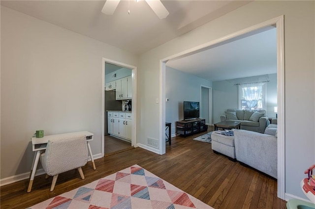 living room featuring visible vents, ceiling fan, baseboards, and dark wood-style flooring