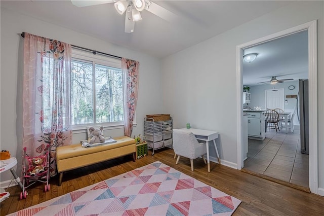 sitting room featuring ceiling fan, baseboards, and wood finished floors