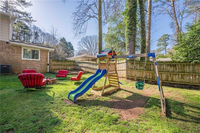 view of playground featuring central air condition unit, a fenced backyard, and a lawn