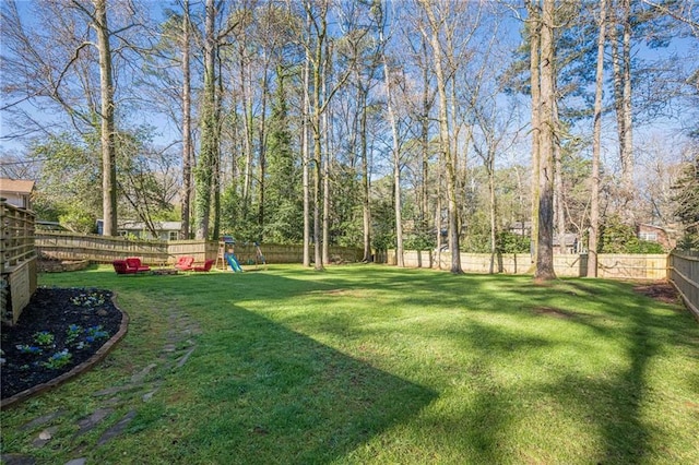 view of yard with a playground and a fenced backyard