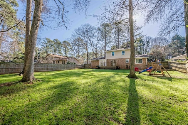 view of yard with a playground and a fenced backyard